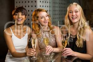 Three smiling friend having glass of champagne