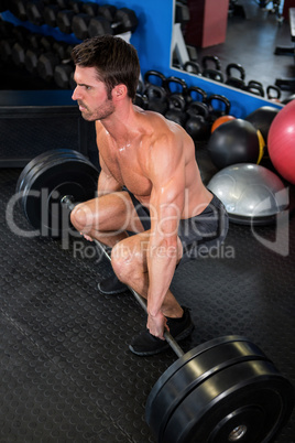 Man lifting barbell in fitness studio