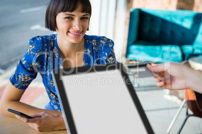 Smiling woman receiving her credit card in coffee shop