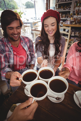 Group of friends toasting cup of coffee