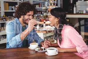 Man feeding dessert to woman