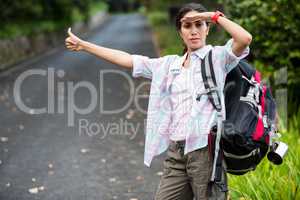 Woman hitchhiking on countryside road