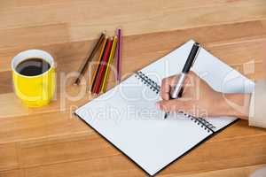 Businesswoman writing on a diary