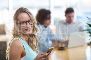 Smiling woman using mobile phone in cafÃ?Â©