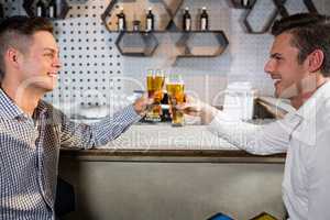 Two men toasting a glass of beer