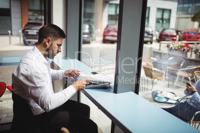 Businessman reading newspaper in office