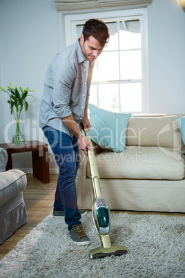 Man cleaning a carpet with a vacuum cleaner