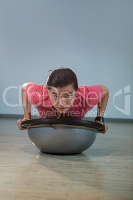 Man doing push-up on bosuball