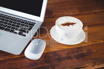 Coffee cup and laptop on a table