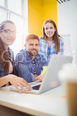 Creative business people looking at laptop