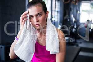 Portrait of young female athlete wiping sweat