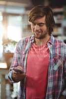 Smiling man using mobile phone