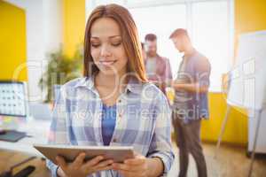 Businesswoman using digital tablet coworkers
