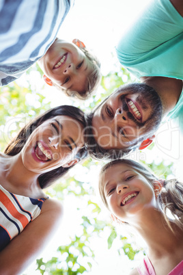 Family forming huddle against sky