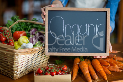 Female staff holding organic sign board