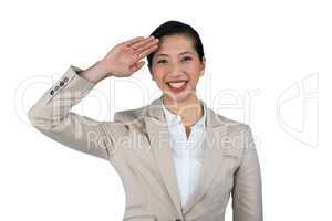 Businesswoman saluting against white background