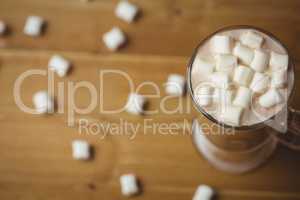 Cup of coffee with marshmallow on wooden table