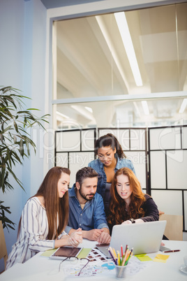 Stylish business people using laptop in meeting room