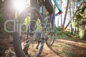 Low section of female mountain biker riding bicycle