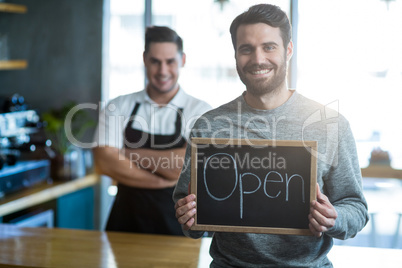 Man holding slate with open sign board in cafÃ?Â©