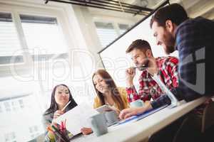 Photo editors discussing about document in meeting room