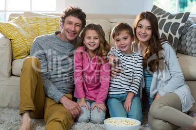 Family watching television while sitting on the floor