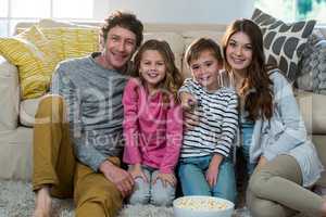 Family watching television while sitting on the floor