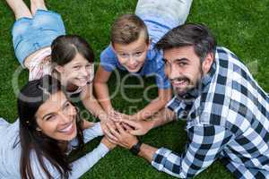 Happy family lying on grass in park on a sunny day