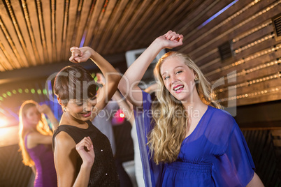 Two beautiful women dancing on dance floor