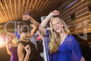 Two beautiful women dancing on dance floor