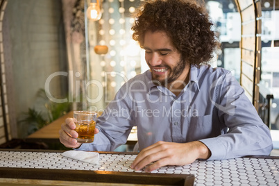 Man having glass of whisky in bar counter