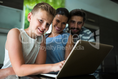 Portrait of happy family using laptop in the living room