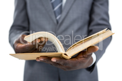 Mid section of businessman flipping the pages of a book