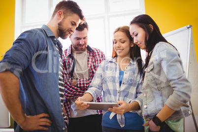 Businesswoman showing digital tablet with coworkers Businesswoman showing digital tablet with coworkers