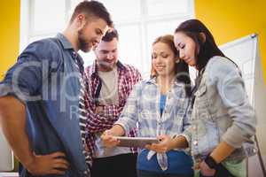 Businesswoman showing digital tablet with coworkers