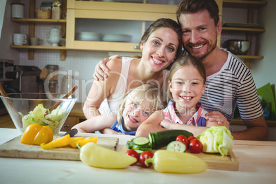 Portrait of happy family leaning on kitchen worktop