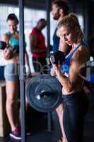 Young woman holding dumbbells in gym