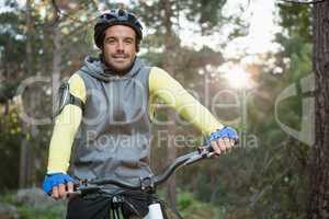 Portrait of male mountain biker riding bicycle in the forest