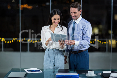 Businessman discussing with colleague over digital tablet