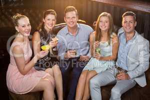 Friends holding glasses of cocktail in bar