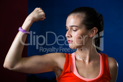 Close-up of woman flexing muscles in gym