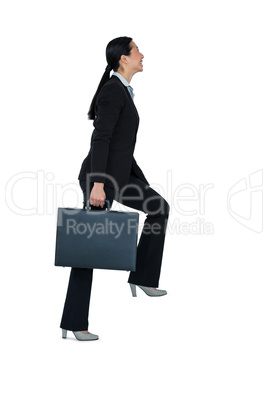 Businesswoman with briefcase walking on stairs