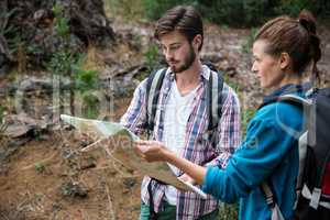 Hiker couple looking at map and compass