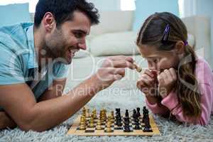 Father and daughter playing chess in the living room