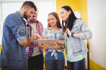 Businesswoman showing digital tablet with coworkers