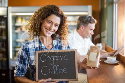 Woman holding a board that reads Organic Coffee