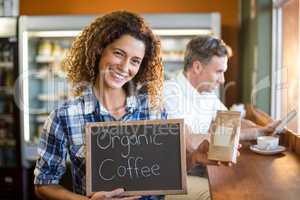 Woman holding a board that reads Organic Coffee