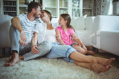 Happy family sitting on the rug in living room