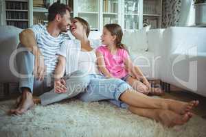 Happy family sitting on the rug in living room