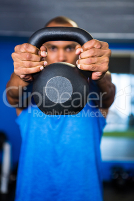 Man covering face with kettlebell